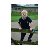 A young boy wearing the lancelot t-shirt by little knight in practical navy blue with contrasting yellow topstitching
