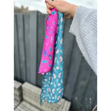 Two colorful lazy sloth cooling bandana pouches in vibrant pink and teal with fun sloth and patterned designs
