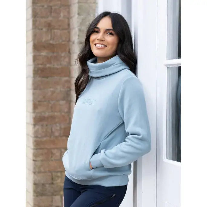 Smiling woman in Lemieux Adele Funnel Neck Sweat Glacier light blue turtleneck sweater