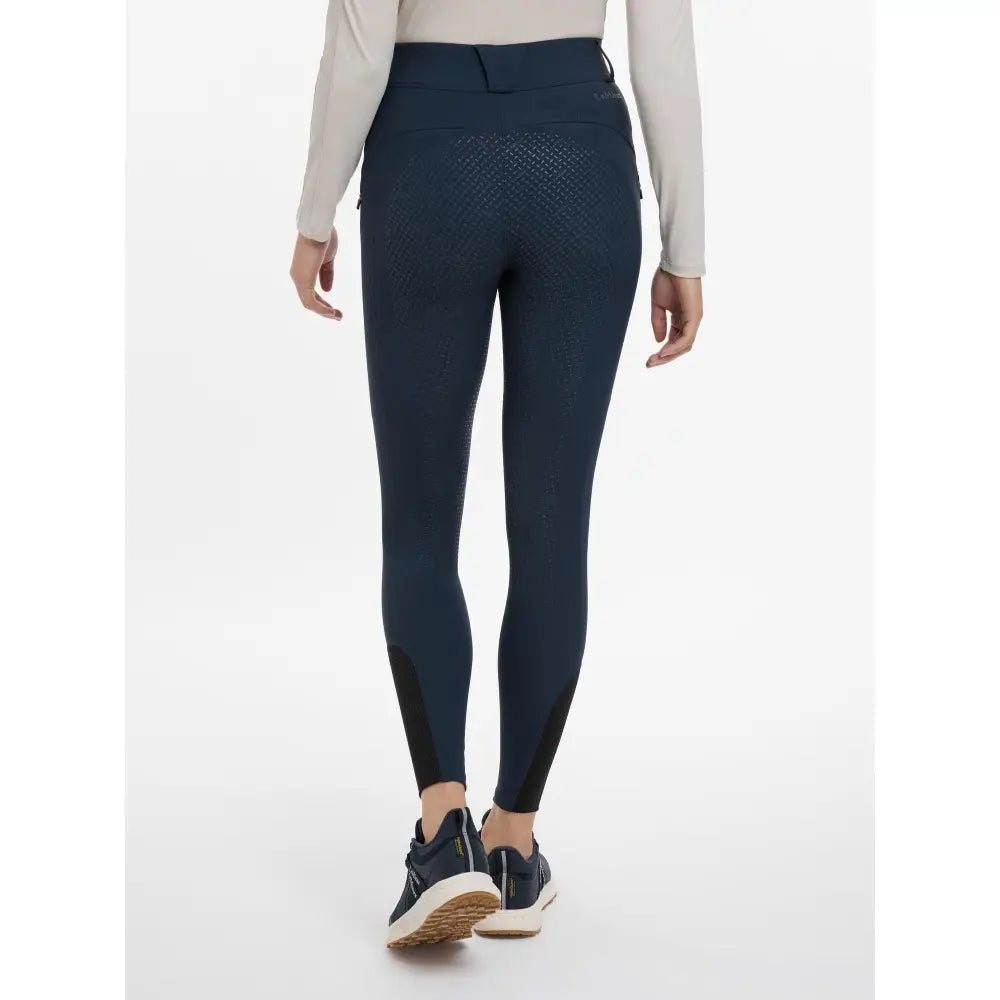 Back view of lemieux amy breggings navy equestrian leggings with textured back pattern and black side panels