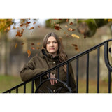 Young woman in green Lemieux Anya Waterproof Riding Coat Alpine with autumn leaves falling