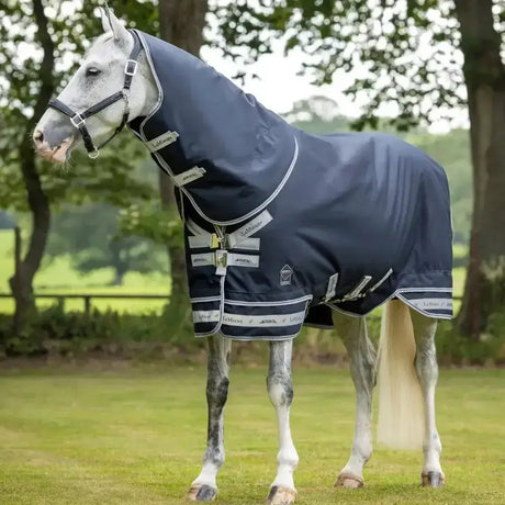 Navy blue lemieux arika featherweight rug with silver trim and beta innovation gold branded patches for horses