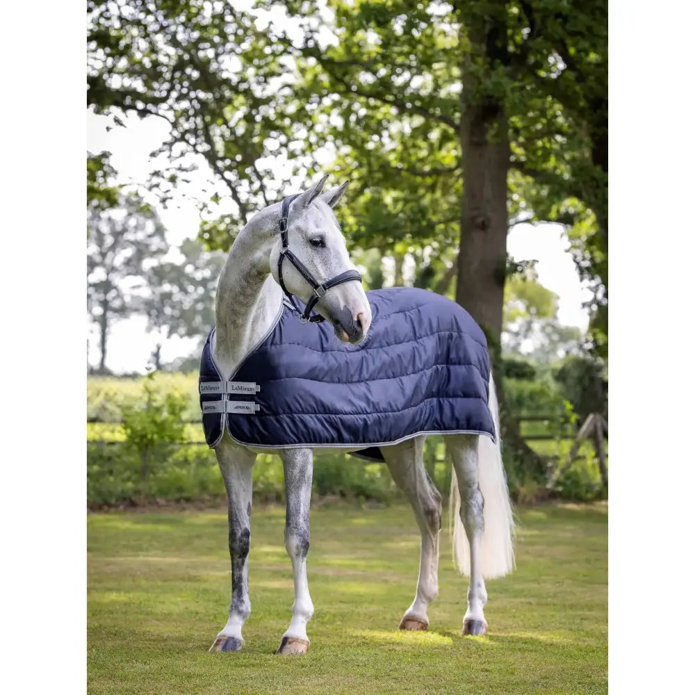 Navy blue quilted lemieux arika liner 100g horse blanket with white trim and brand logo patches for warmth and comfort