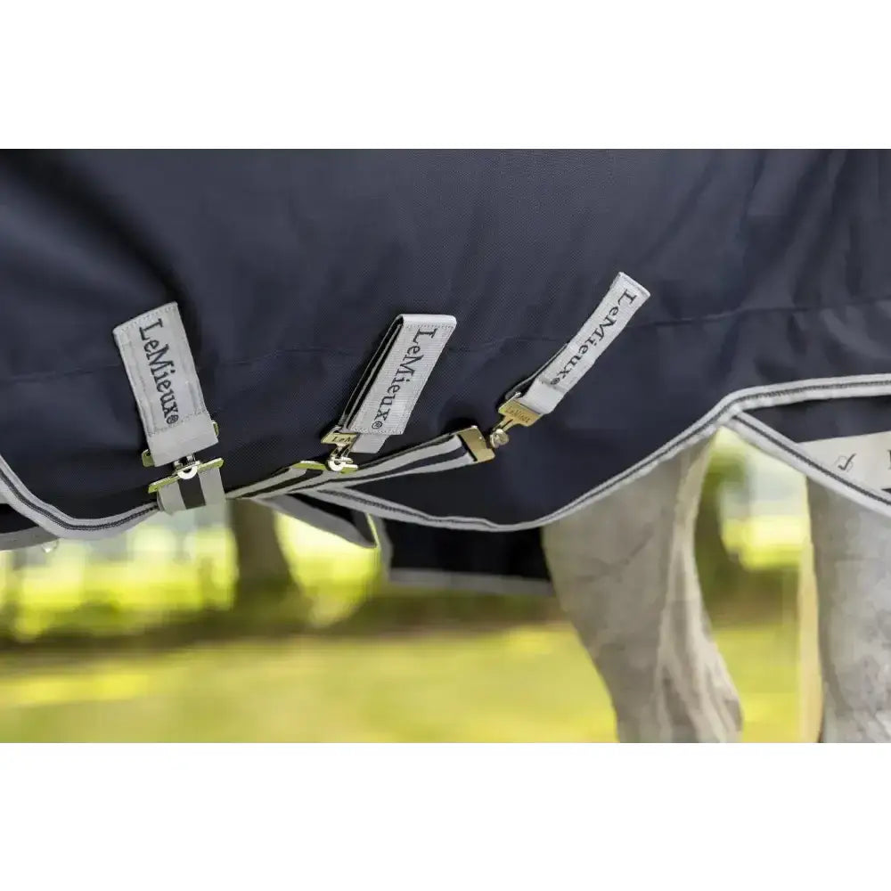 Dark navy blue lemieux arika storm-tek rug 50g with white trim gold-toned beta innovation gold hardware and branded tags