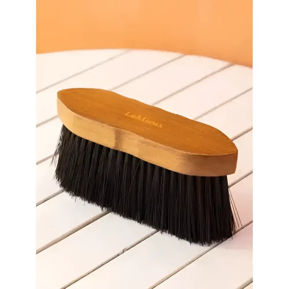 A lemieux artisan flick brush brown with a wooden crafted handle, dense black bristles, and special grooves engraving
