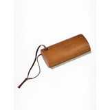 A smooth light brown wooden artisan shedding comb brown by lemieux artisan shedding with a black cord attached