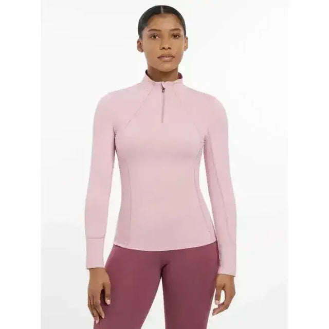 A soft pink lemieux base layer blossom with long sleeves and a quarter-zip collar in a sleek, form-fitting design
