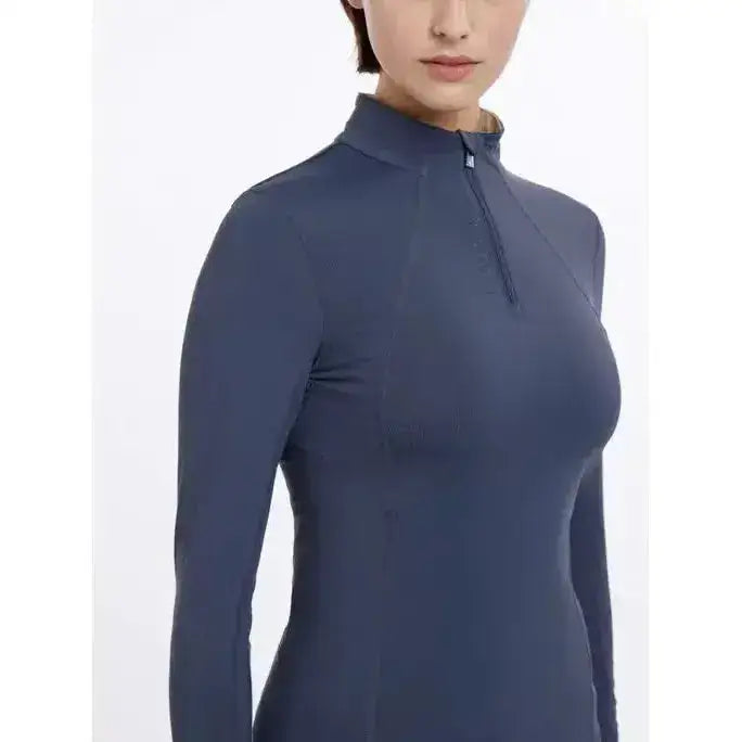 A sleek navy blue lemieux base layer dusk blue long-sleeve top with high collar and quarter-zip closure
