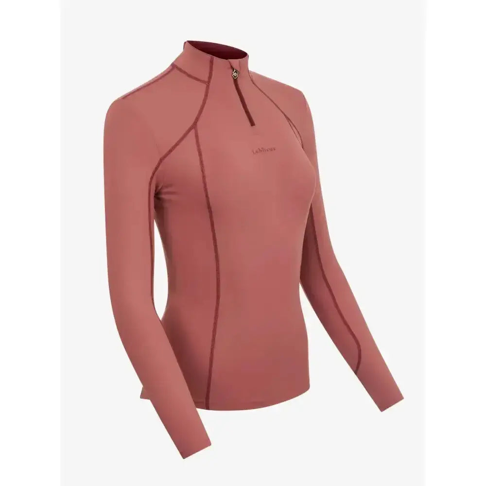 A soft rose-colored lemieux base layer orchid with long sleeves high collar and subtle dark stitching for unrestricted comfort