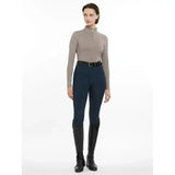 A woman wears navy blue lemieux base layer pecan riding pants with a high waist and fitted silhouette paired with a matching top