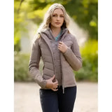 A woman wearing a lemieux pecan brioney hybrid jacket in beige with quilted hood panel and zipper closure