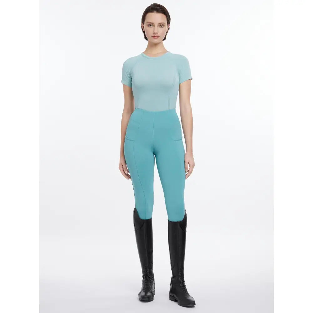 A sleek lemieux britney seamless short aqua top with matching teal high-waisted leggings and subtle pockets