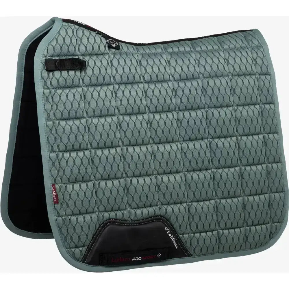 A quilted sage green lemieux carbon mesh dressage square with black trim and reinforced corners