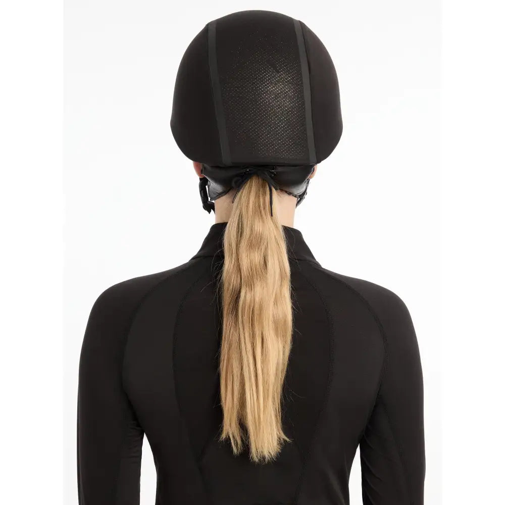 Black equestrian helmet with blonde ponytail under LeMieux Carmine Hat Silk Black