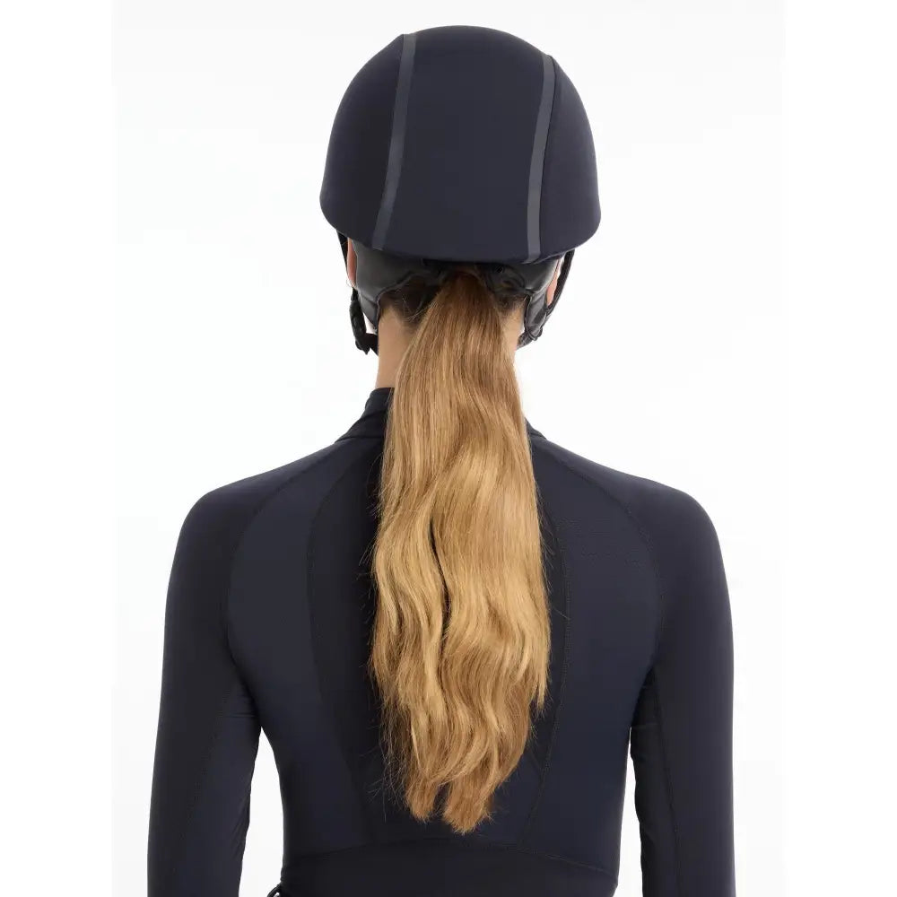 Equestrian riding helmet with long blonde hair under Lemieux Carmine Hat Silk Navy