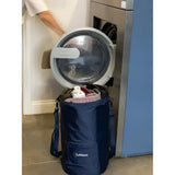 Blue lemieux carry all backpack navy laundry bag with front pocket and shoulder strap next to open washing machine equestrian use