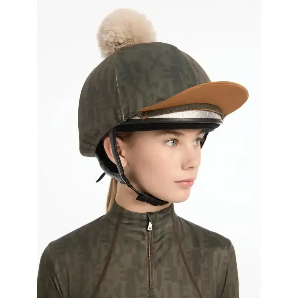 Olive green lemieux casey hat silk alpine cover with tan brim and beige pom-pom for equestrian use