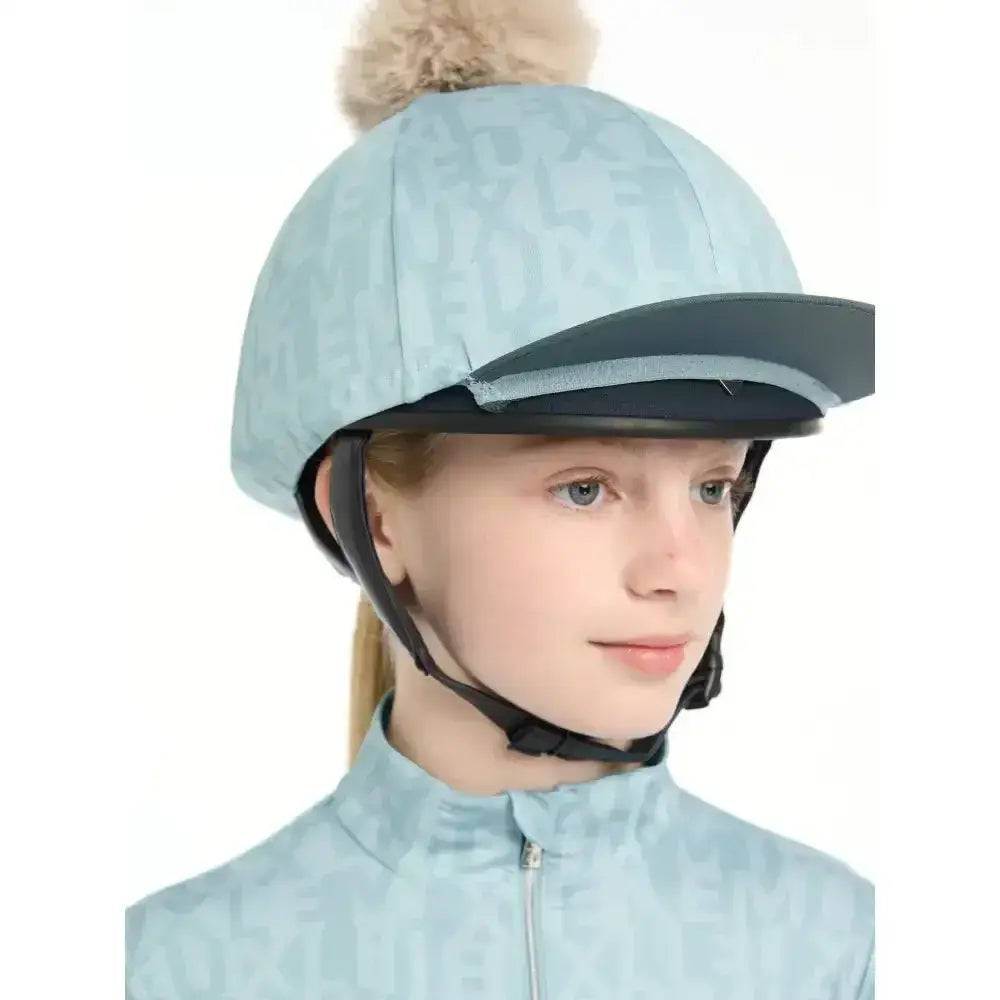Light blue lemieux casey hat silk glacier equestrian helmet with black brim and beige pom-pom on top