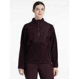 A dark maroon lemieux clara hybrid fleece pullover with long sleeves half-zip and subtle textured pattern
