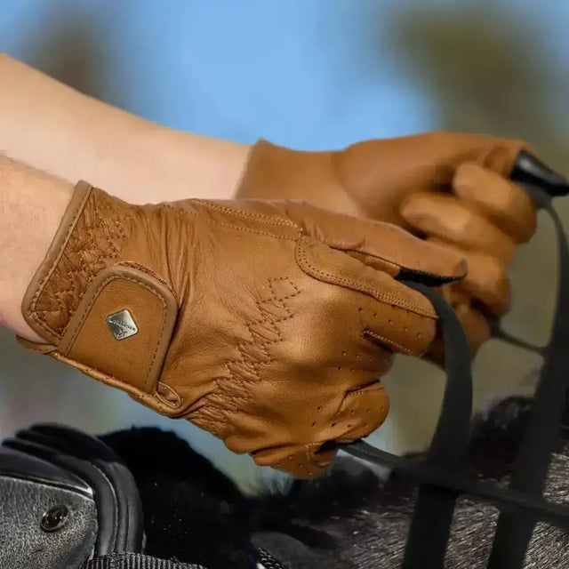 Lemieux classic leather riding gloves in simple brown leather with intricate stitching and a small metallic logo on wrist strap