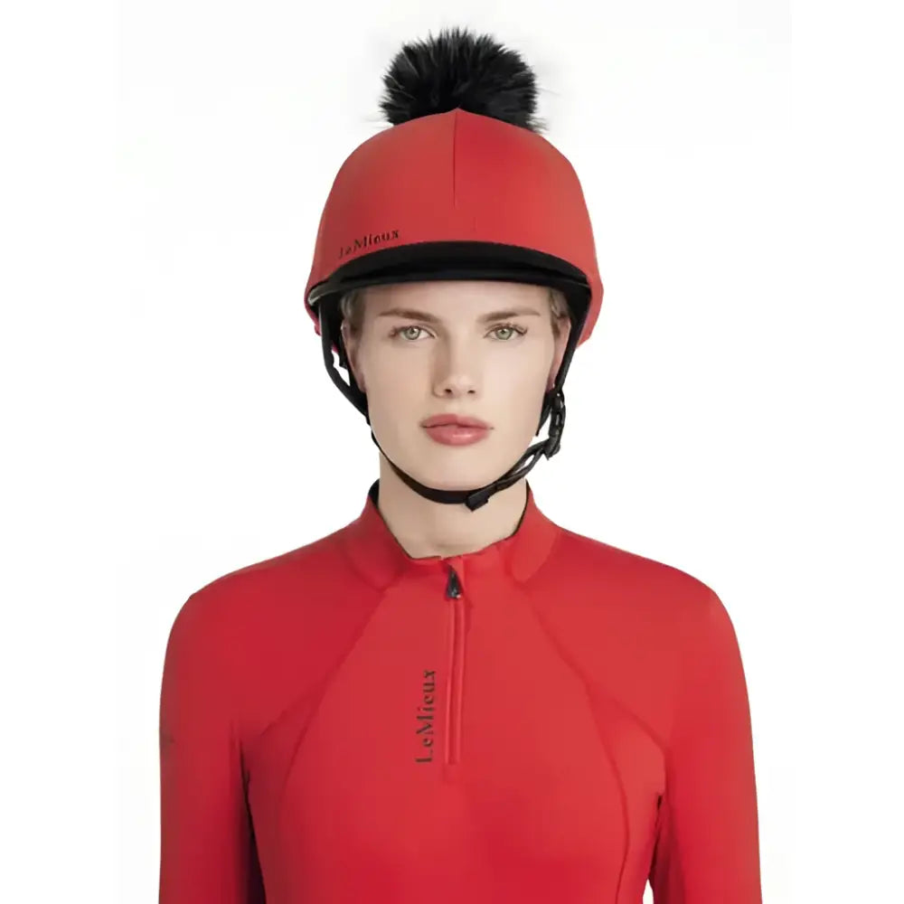 Red lemieux classique pom equestrian helmet with black trim and fluffy pom hat silk chilli on top