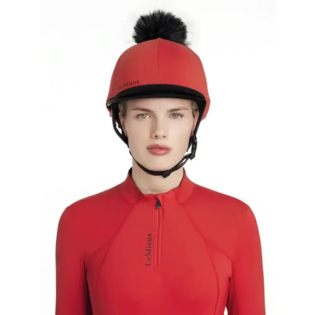 Red lemieux classique pom equestrian helmet with black trim and fluffy pom hat silk chilli on top