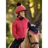 Pink quilted lemieux classique pom riding helmet with black brim and dark pom hat silk cranberry for riding