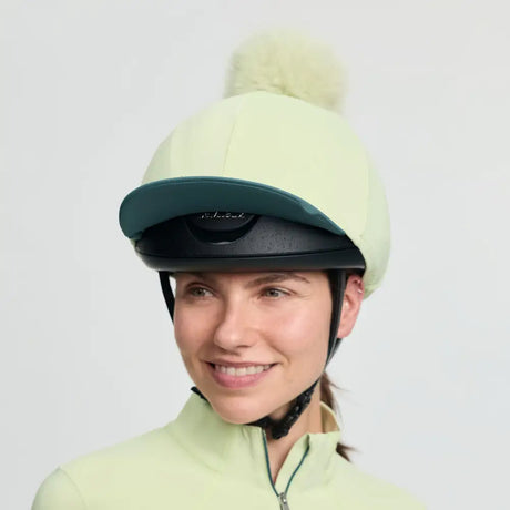 Lemieux classique pom equestrian helmet in pale green with dark teal brim and cream faux fur pom silk macaron style