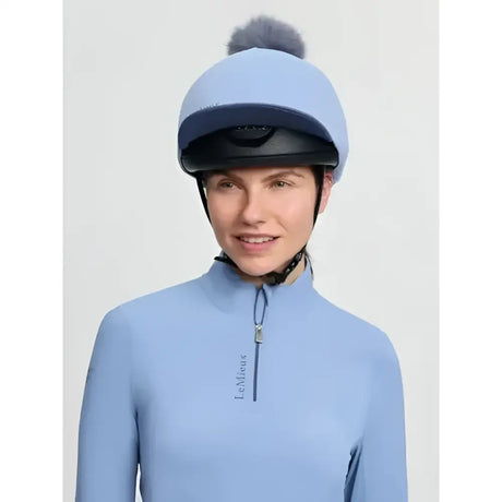 Light blue lemieux classique pom equestrian helmet with dark gray faux fur pom in silk powder blue finish