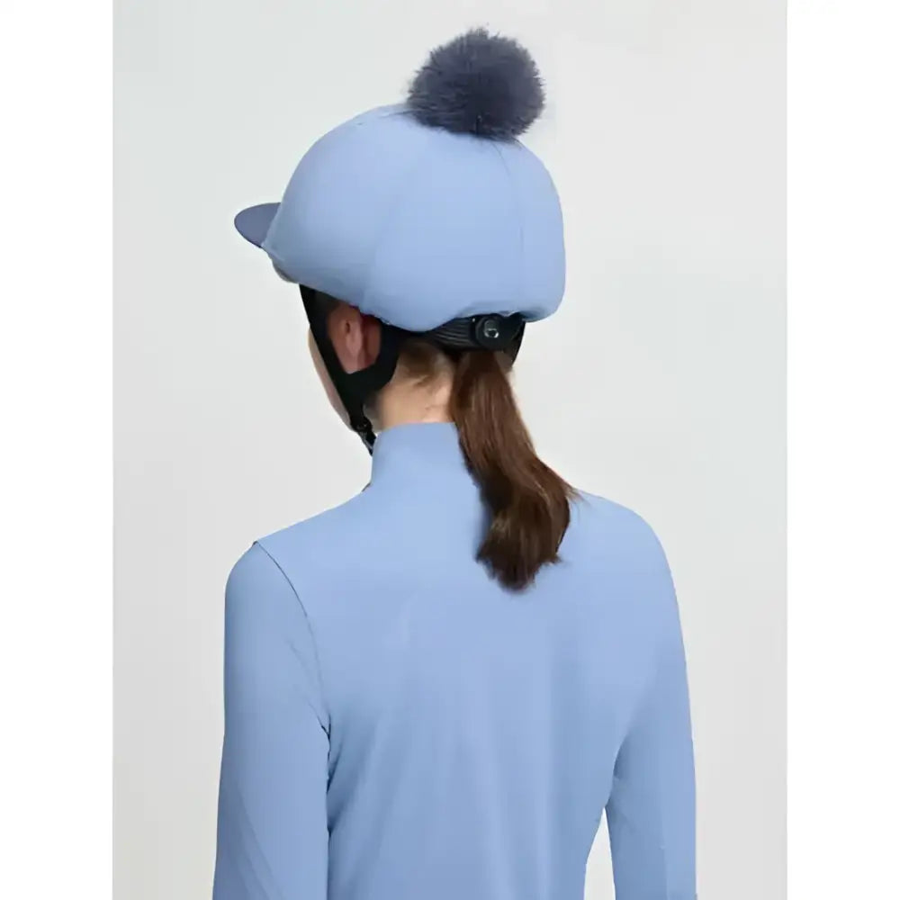 Light blue lemieux classique pom equestrian helmet with a fluffy dark gray faux fur pom in silk powder blue