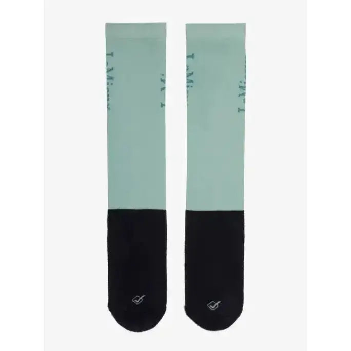 A pair of lemieux competition socks in mint green and black with subtle i am text on the upper leg