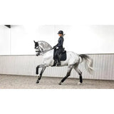 A sleek dapple-gray horse with black lemieux crystal suede dressage saddle and leather girth protection wraps