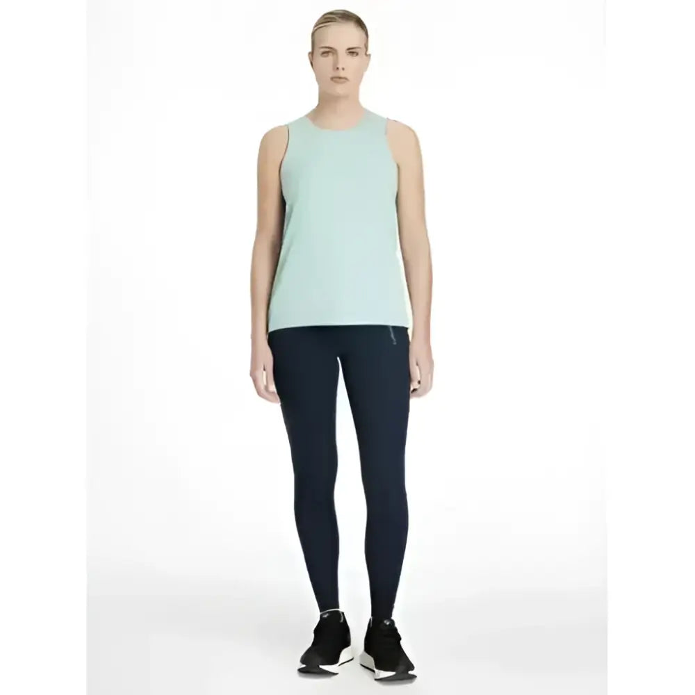 A woman wearing a light mint green tank top with lemieux dani sport legging navy in smooth, form-fitting fabric
