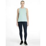 A woman wearing a light mint green tank top with lemieux dani sport legging navy in smooth, form-fitting fabric