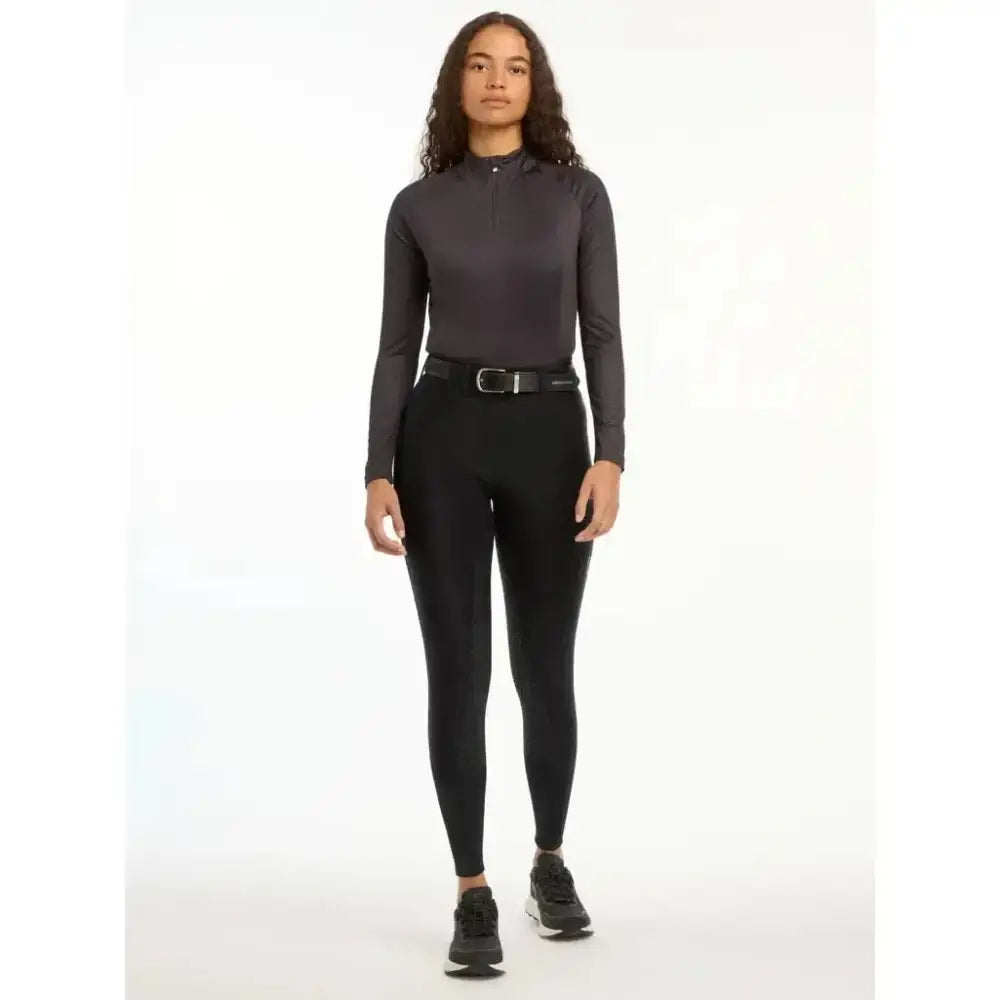 Black long-sleeved high-neck athletic top with subtle gradient finish paired with lemieux demi pull breggings black full-seat silicone grip