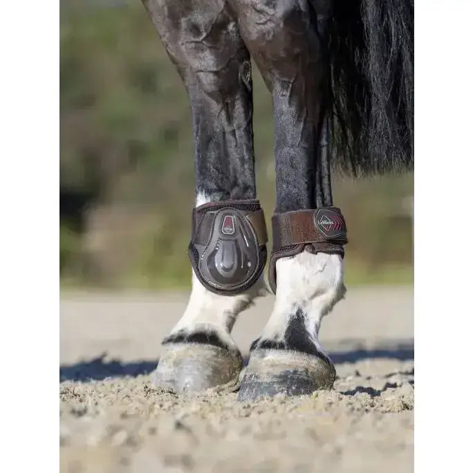 Brown leather lemieux derby projump fetlock boot with black plastic shell and red logo for horse hoof protection