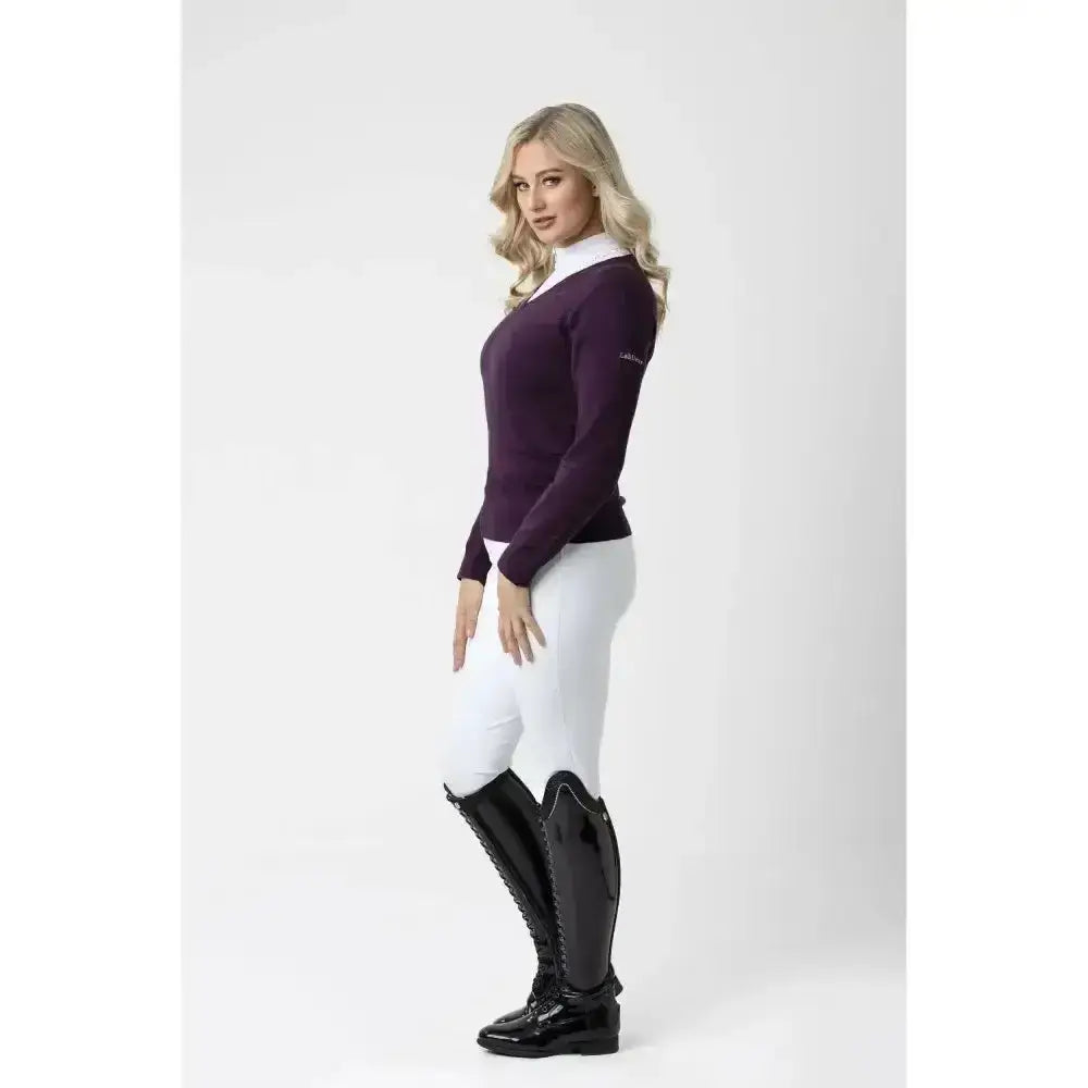 A woman wears a sleek purple equestrian top paired with lemieux drytex waterproof breeches with knee grip in white