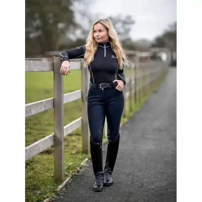 Black long-sleeved equestrian top with white piping and silver zipper matched with lemieux drytex waterproof breeches black