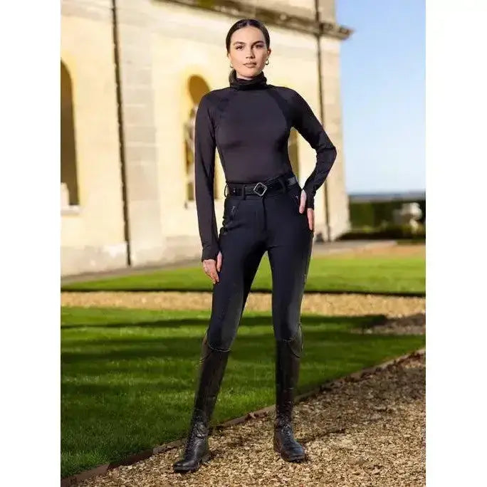 Black high neck long sleeve riding top with seamless design and subtle side seams pairs with lemieux drytex breeches for all-weather riding