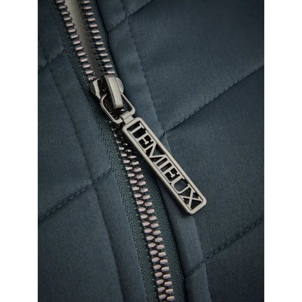 Metal zipper with DEMETER pull tab on Lemieux Dynamique Jacket Petrol’s dark quilted fabric