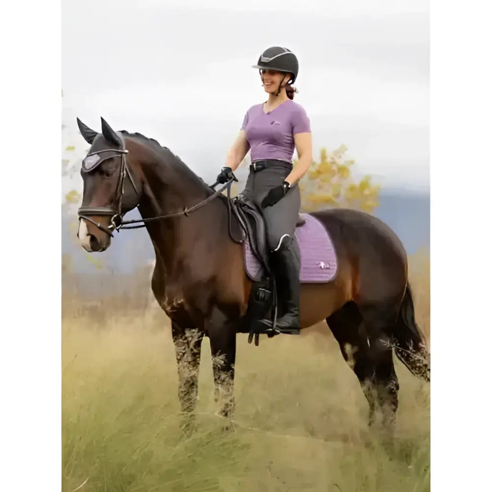 Purple quilted lemieux earth dressage square thistle saddle pad with subtle logo on dark brown horse for dressage use