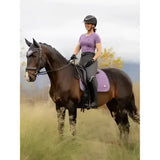 Purple quilted lemieux earth dressage square thistle saddle pad with subtle logo on dark brown horse for dressage use