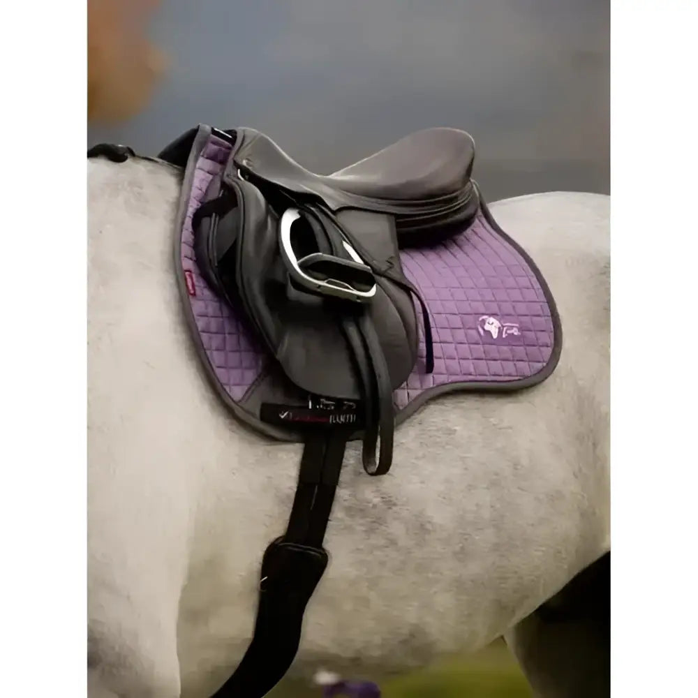 Purple quilted lemieux earth purpose saddle pad with black trim and small logo under dark brown saddle square thistle