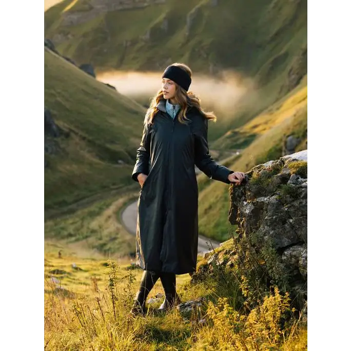 Woman in a Lemieux Elements Coat Navy and beanie standing on a scenic hillside