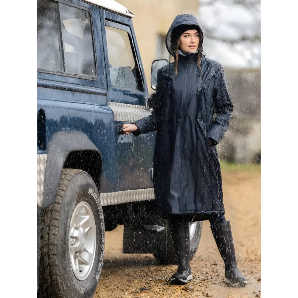 Woman in a dark Lemieux Elements Coat Navy beside a blue off-road vehicle