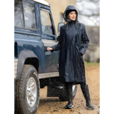 Woman in a dark Lemieux Elements Coat Navy beside a blue off-road vehicle