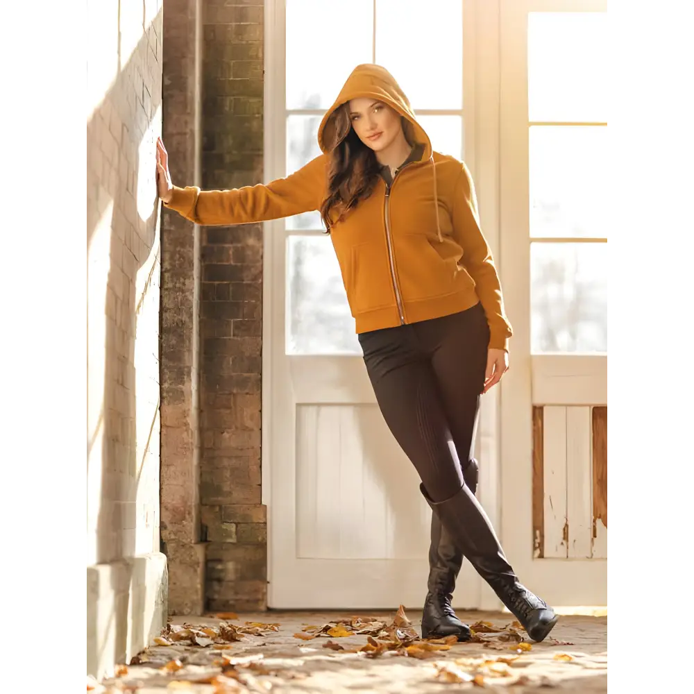 Woman in a mustard yellow Lemieux Elle Zip Through Hoodie Ginger and dark pants