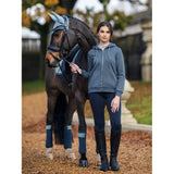 Woman in equestrian attire beside a brown horse wearing Lemieux Elle Zip hoodie