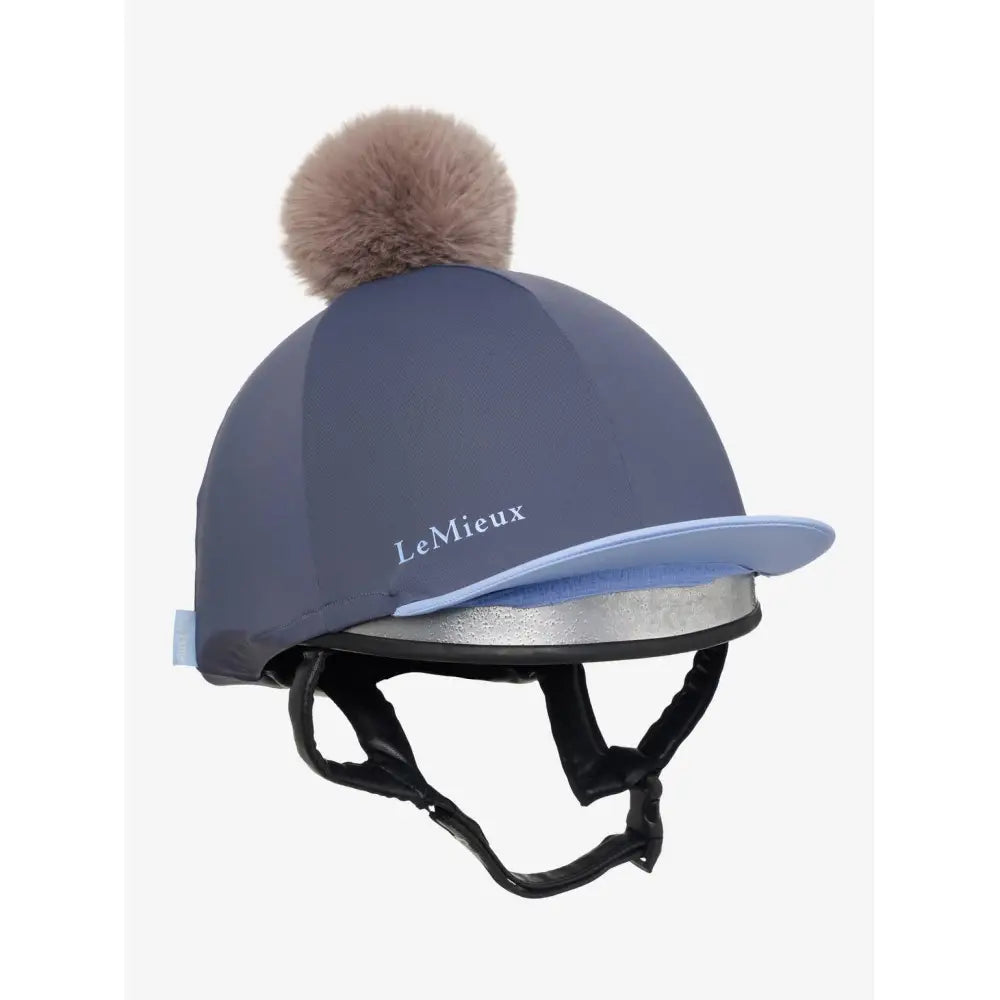 A lemieux esme hat silk dusk blue equestrian helmet cover with navy blue silk, light blue brim, silver band, and beige pom pom