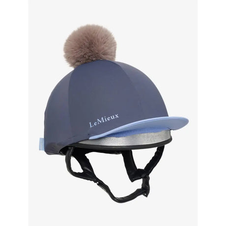 A lemieux esme hat silk dusk blue equestrian helmet cover with navy blue silk, light blue brim, silver band, and beige pom pom
